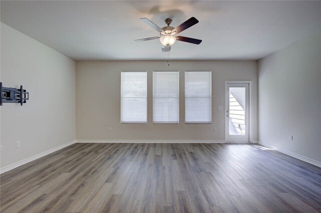 spare room featuring hardwood / wood-style flooring, ceiling fan, and a healthy amount of sunlight