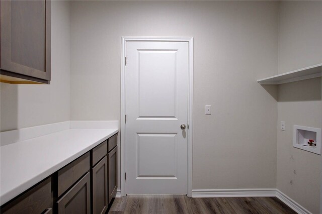 clothes washing area with cabinets, dark hardwood / wood-style floors, and washer hookup