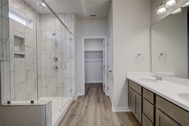 bathroom with hardwood / wood-style flooring, vanity, and walk in shower