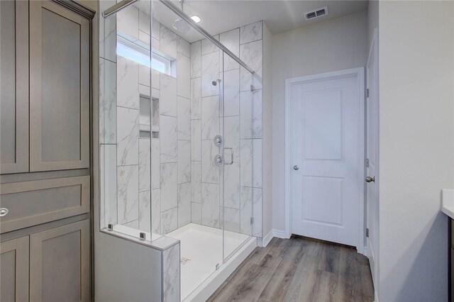 bathroom featuring vanity, hardwood / wood-style flooring, and walk in shower