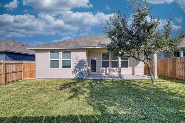 rear view of house with a lawn and a patio area