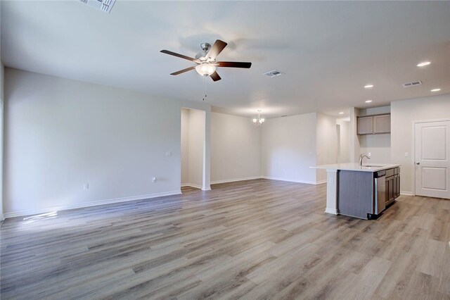 unfurnished living room featuring sink, ceiling fan with notable chandelier, and light wood-type flooring