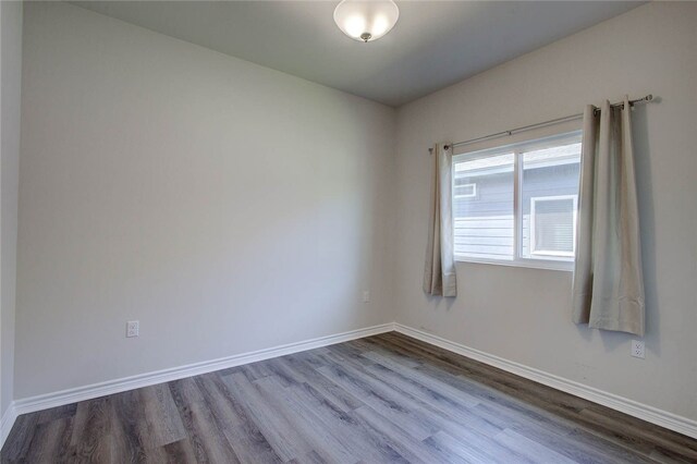 unfurnished room with hardwood / wood-style flooring