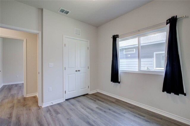 unfurnished bedroom with a closet and light wood-type flooring