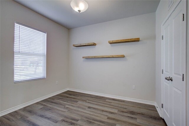 empty room with plenty of natural light and wood-type flooring