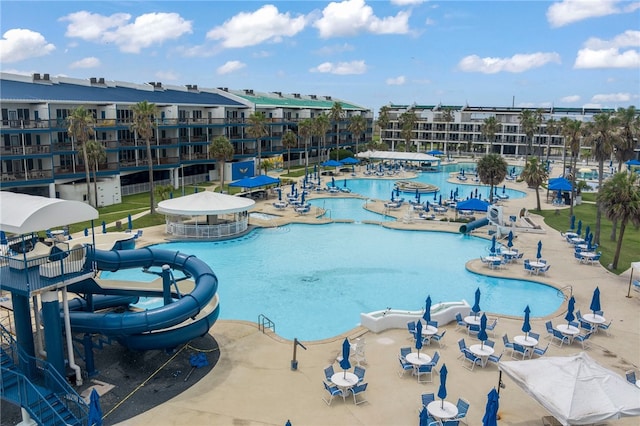 view of pool featuring a water slide and a patio area