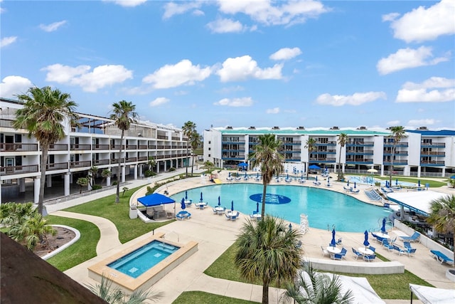 view of swimming pool featuring a hot tub and a patio area