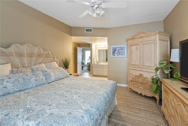 bedroom featuring ceiling fan, ensuite bath, and light tile patterned floors