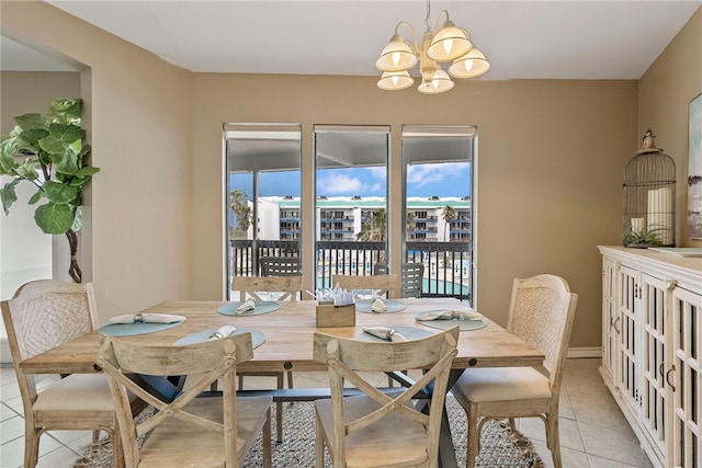 tiled dining space featuring plenty of natural light and a notable chandelier