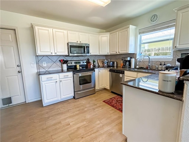 2418 Mystic Star Dr, Corpus Christi, TX 78414 - kitchen featuring appliances with stainless steel finishes, a sink, dark countertops, and light wood-style flooring