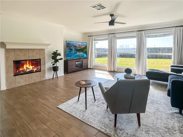 2418 Mystic Star Dr, Corpus Christi, TX 78414 - living room featuring crown molding, wood finished floors, a fireplace, a ceiling fan, and baseboards