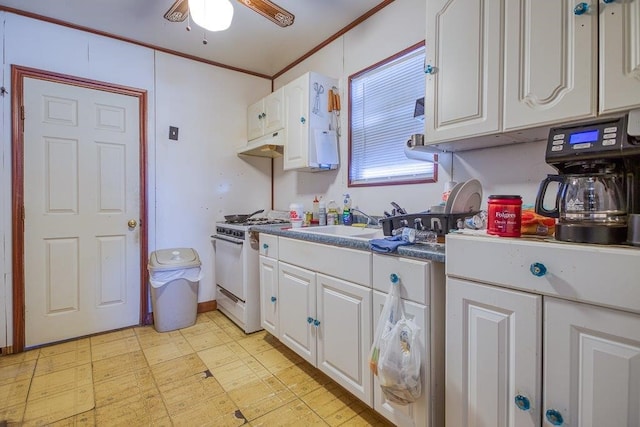 kitchen featuring white gas range, ornamental molding, ceiling fan, sink, and white cabinets