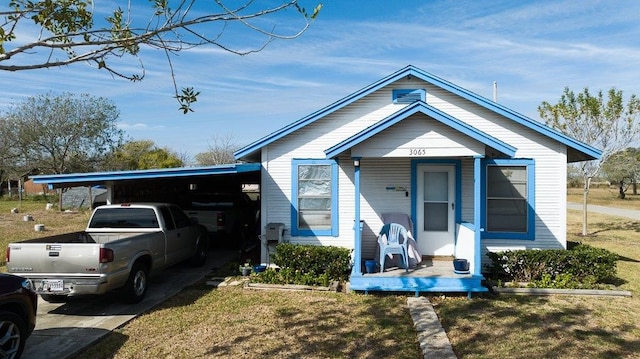 view of front of property featuring a front lawn, a porch, and a carport