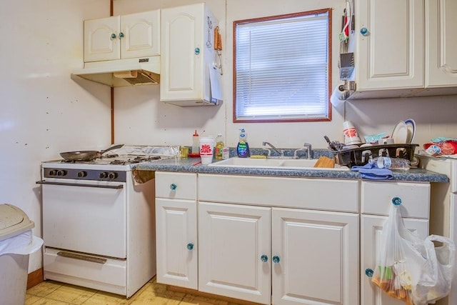 kitchen with white cabinets, white gas stove, and sink