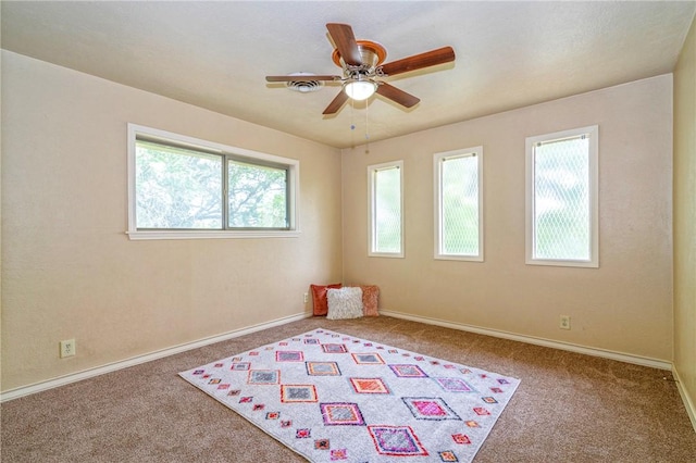 spare room with a ceiling fan, baseboards, and carpet