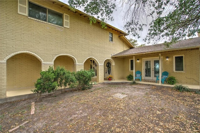 back of property with brick siding, a patio, and french doors