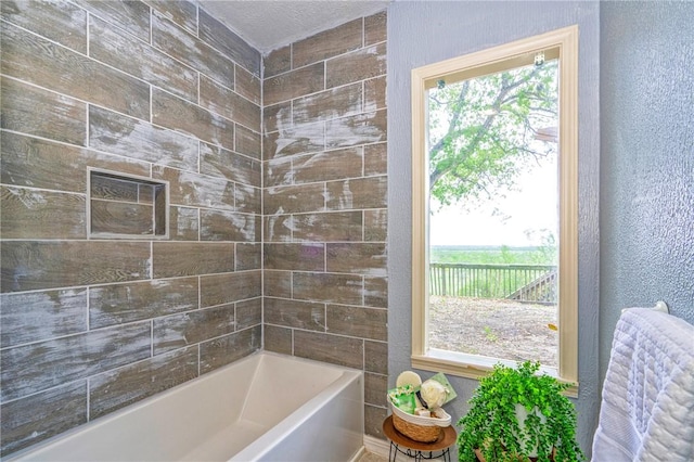 full bathroom featuring a textured wall and shower / bathtub combination