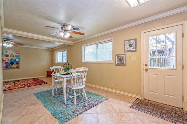 dining area with a textured ceiling, baseboards, ornamental molding, ceiling fan, and light tile patterned floors