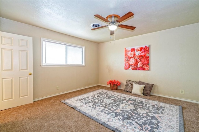 sitting room with baseboards, visible vents, carpet, and ceiling fan