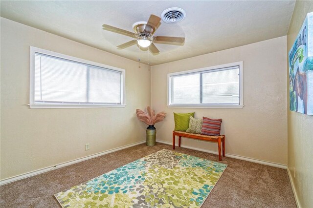 sitting room with visible vents, baseboards, carpet flooring, and ceiling fan