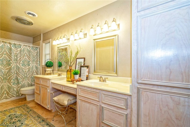 full bathroom featuring toilet, a sink, visible vents, and double vanity