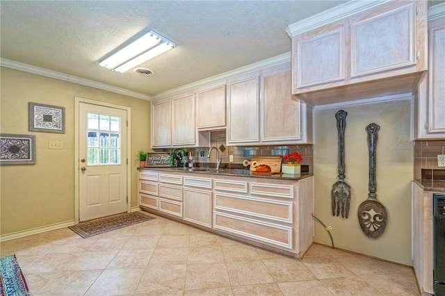 kitchen with a sink, dark countertops, visible vents, decorative backsplash, and ornamental molding