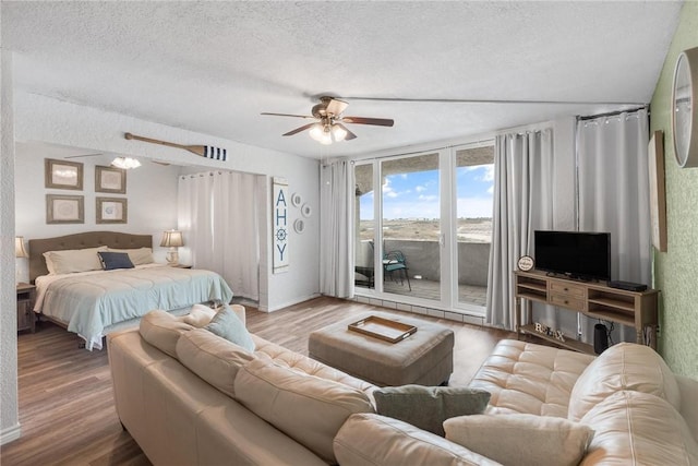 bedroom featuring access to outside, a textured ceiling, and wood finished floors