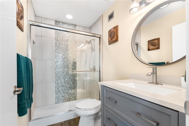 bathroom with hardwood / wood-style flooring, vanity, toilet, and walk in shower