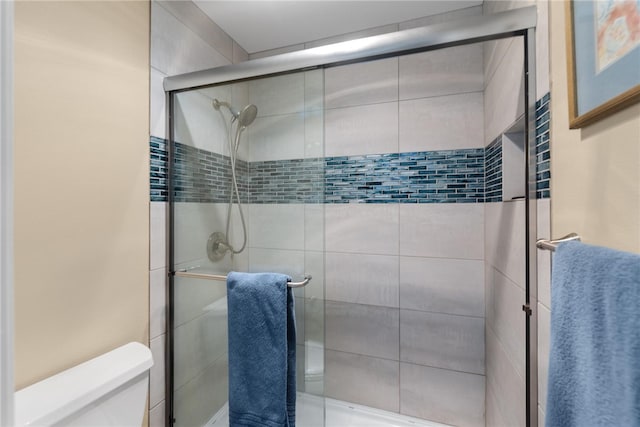 bathroom with toilet and a shower with shower door