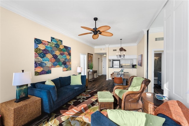 living room with crown molding, dark wood-type flooring, and ceiling fan with notable chandelier