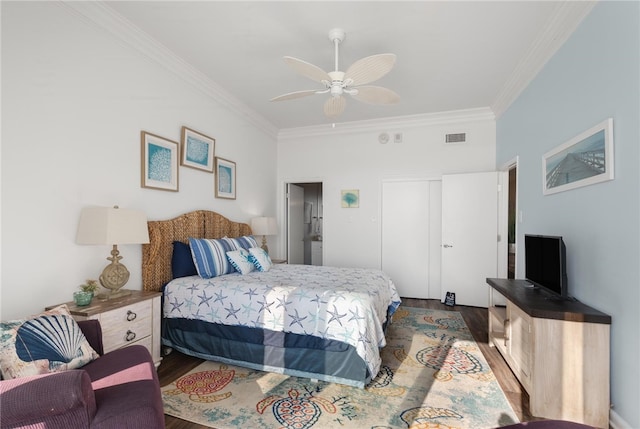 bedroom with ceiling fan, ornamental molding, and dark wood-type flooring