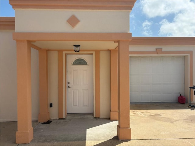 915 Flour Bluff Dr, Corpus Christi, TX 78418 - doorway to property featuring a garage, stucco siding, and driveway