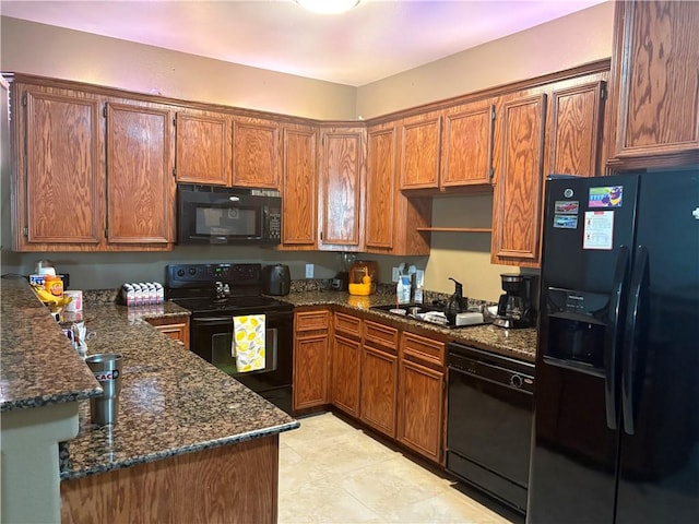 915 Flour Bluff Dr, Corpus Christi, TX 78418 - kitchen featuring black appliances, a sink, dark stone countertops, and brown cabinetry
