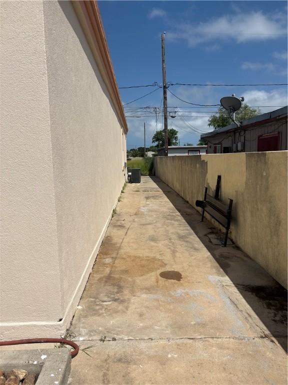 915 Flour Bluff Dr, Corpus Christi, TX 78418 - view of side of home with stucco siding, central air condition unit, and a patio area