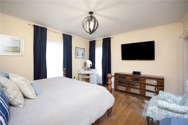 bedroom with ornamental molding and dark wood-type flooring