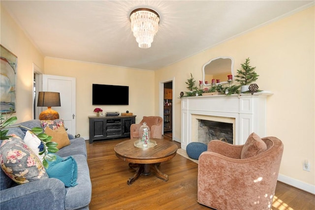 living room featuring a notable chandelier, wood-type flooring, and crown molding