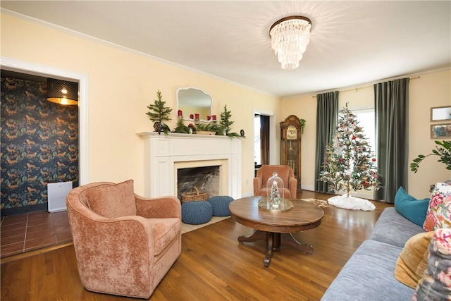 living room featuring hardwood / wood-style flooring, ornamental molding, and an inviting chandelier