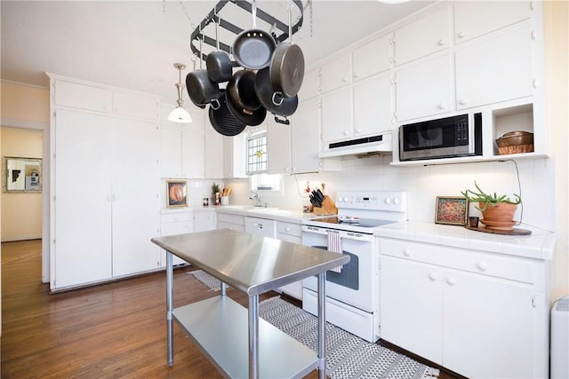 kitchen with white electric range oven, dark wood-type flooring, tile countertops, white cabinetry, and stainless steel microwave