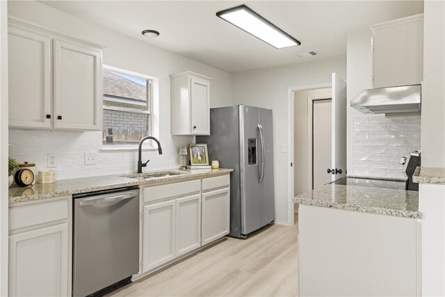 7926 Falcon Dr, Corpus Christi, TX 78414 - kitchen featuring stainless steel appliances, under cabinet range hood, decorative backsplash, light wood-type flooring, and light stone countertops