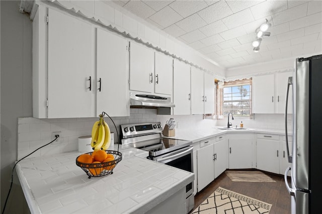 kitchen featuring dark wood-type flooring, tile countertops, white cabinets, sink, and appliances with stainless steel finishes