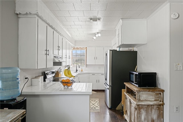 kitchen with white cabinets, kitchen peninsula, stainless steel appliances, and sink