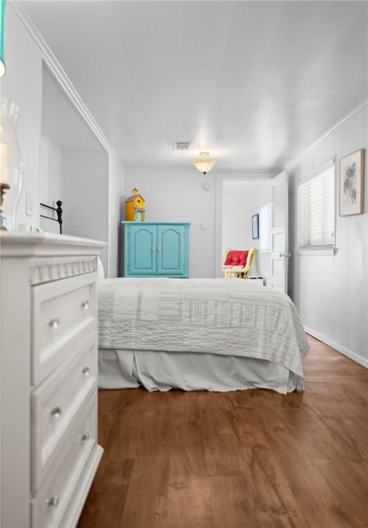 bedroom featuring visible vents and wood finished floors