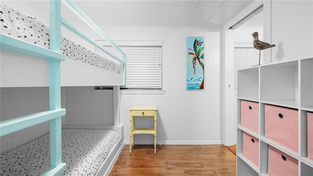 bedroom featuring baseboards, ornamental molding, and wood finished floors