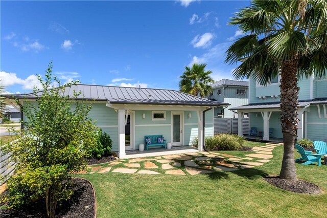 126 Reserve Ln, Rockport, TX 78382 - rear view of property with a standing seam roof, a yard, metal roof, and covered porch