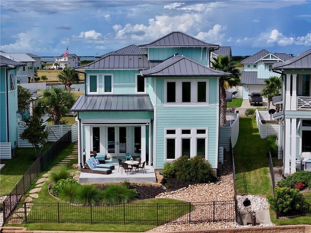 126 Reserve Ln, Rockport, TX 78382 - rear view of house featuring a standing seam roof, board and batten siding, metal roof, french doors, and a residential view