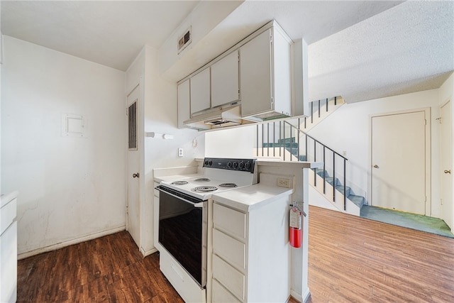 kitchen with white electric range oven, dark hardwood / wood-style floors, and a textured ceiling