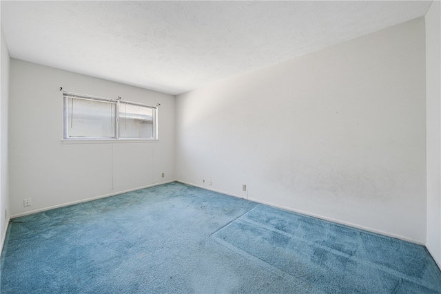 unfurnished room with carpet and a textured ceiling