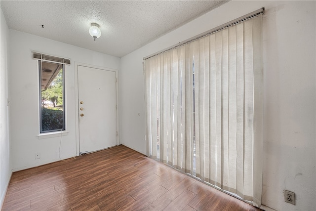 entryway with wood-type flooring and a textured ceiling