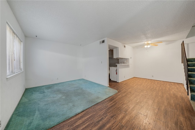 unfurnished living room with hardwood / wood-style flooring, ceiling fan, and a textured ceiling