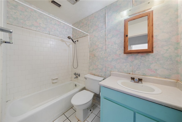 full bathroom featuring tile patterned floors, vanity, tiled shower / bath, and toilet